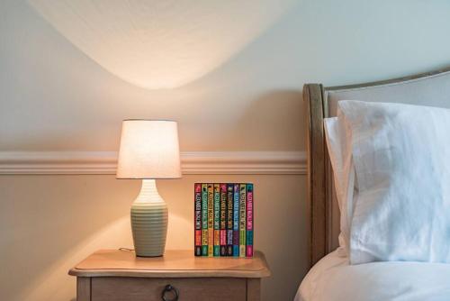a lamp on a night stand next to a bed at Admiralty House in Deal