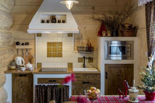a kitchen with a sink and a microwave and a stove at Osada Maruszyna in Szaflary
