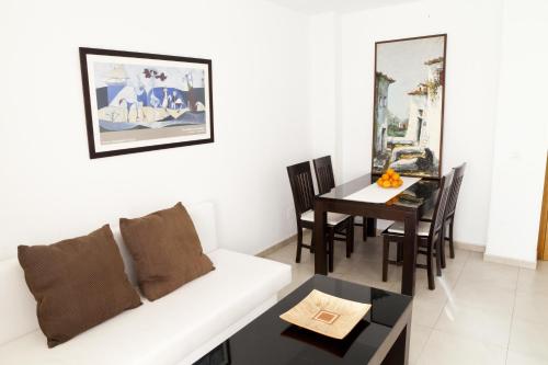 sala de estar con sofá blanco y mesa en Apartamentos Carolina, en Torremolinos