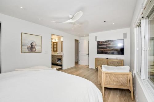 a white bedroom with a white bed and a window at Oceanfront Luxury, Fully Remodeled, Five-Star in Solana Beach