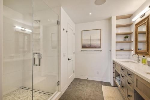 a white bathroom with a shower and a sink at Oceanfront Luxury, Fully Remodeled, Five-Star in Solana Beach