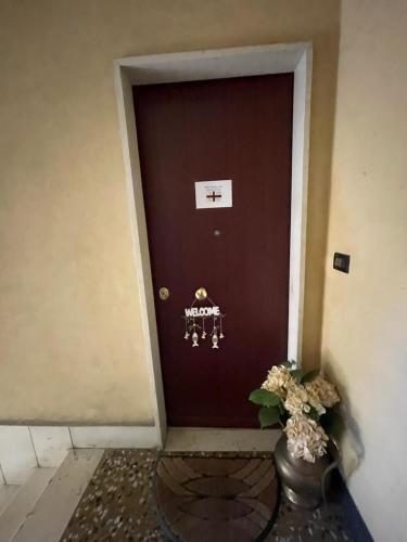 a brown door with a vase with flowers in front of it at Zena in Genoa