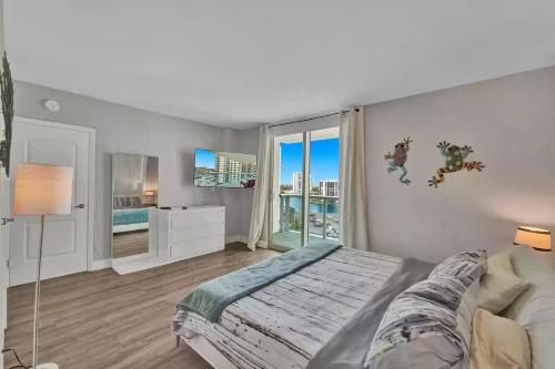 a bedroom with a bed and a large window at Amazing Apartment on hollywood beach TIDES in Hollywood