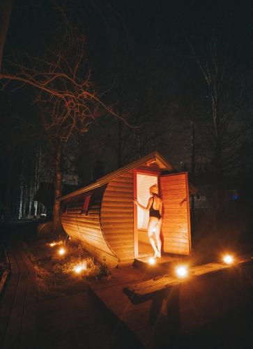 a woman standing in the doorway of a tiny house at night at Laawu Kultaa in Kotka