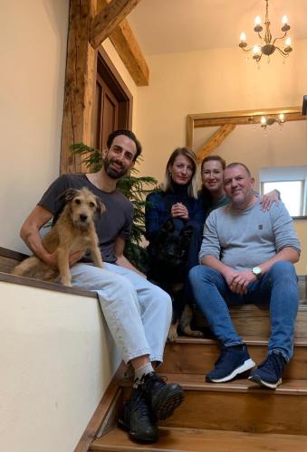 a group of people sitting on the stairs with a dog at VILLA ANGEL in Rožňava