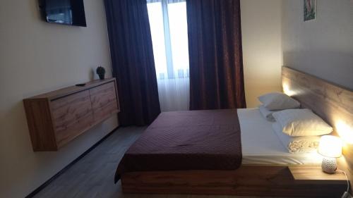 a small bedroom with a bed and a window at MAFA Hotel in Bukovel