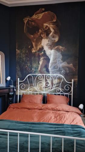 uma cama com uma grande pintura na parede em De Cosy Barock met gezellige Patio ! em Breda