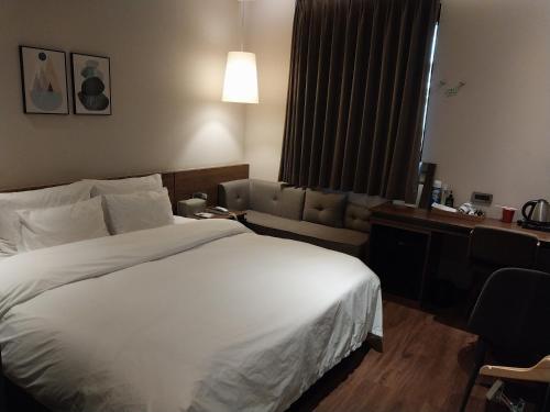 a hotel room with a large bed and a couch at Brown Dot Hotel Busan Station in Busan