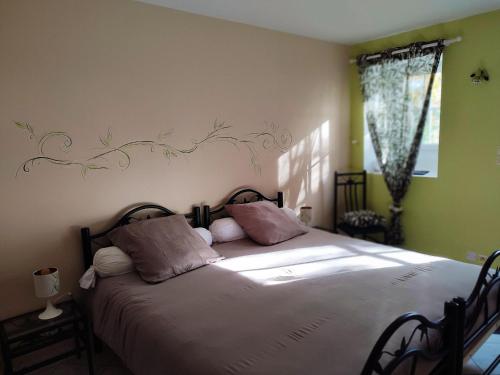 una camera da letto con un grande letto con lenzuola e cuscini bianchi di AU NID DOUILLET DE LA FERME CHAUVET a Chantenay-Villedieu