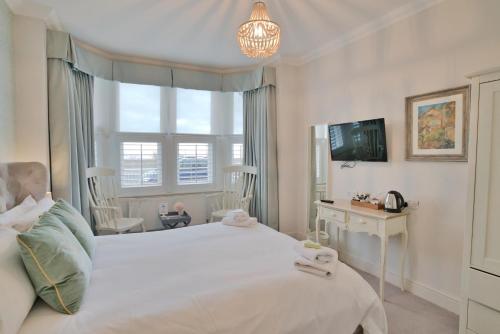 a bedroom with a large white bed and a window at Beaches Guest House in Southend-on-Sea