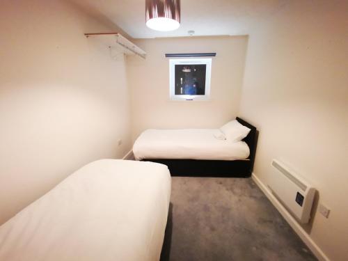 サウサンプトンにあるCity Centre Comfortのベッド2台と窓が備わる小さな客室です。