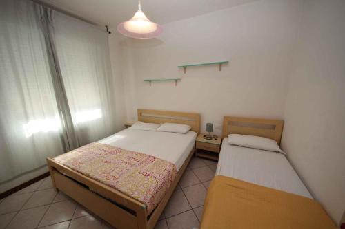ロゾリーナ・マーレにあるApartment in Rosolina Mare 25019のベッドルーム(ベッド2台、照明付)