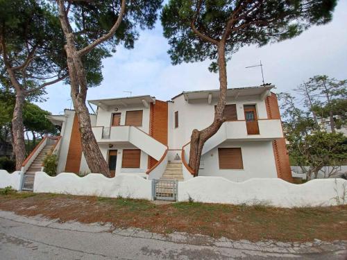 een huis met twee bomen ervoor bij Apartment in Rosolina Mare 24985 in Rosolina Mare