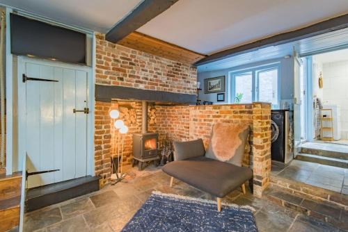 a living room with a brick fireplace and a chair at Old Chelsea in Deal