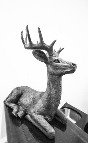 a statue of a deer sitting on a stove at HELIOPARK Bad Hotel Zum Hirsch in Baden-Baden