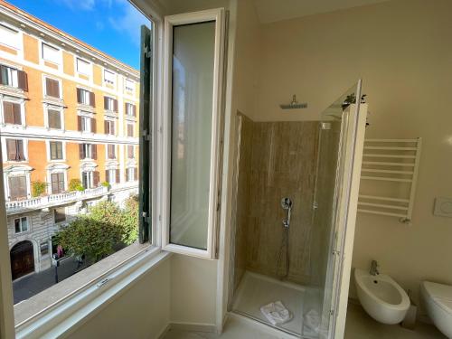 La salle de bains est pourvue d'une douche, de toilettes et d'une fenêtre. dans l'établissement Quintus Luxury Suites, à Rome