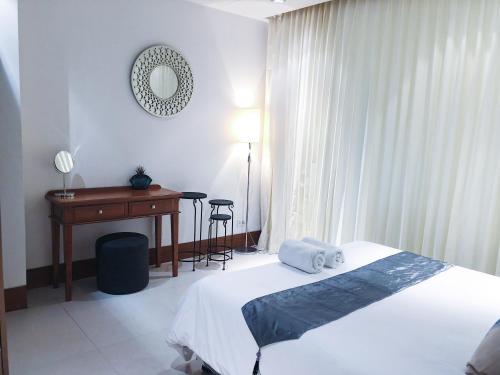 a bedroom with a bed and a desk and a table at Beachfront 2br home with private plunge pool on stunning Naithon beach 3 in Nai Thon Beach