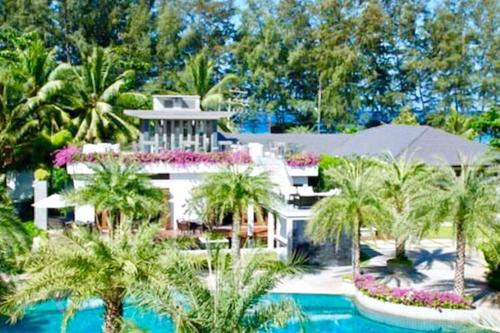 a large white house with palm trees and a swimming pool at Beachfront 2br home with private plunge pool on stunning Naithon beach 3 in Nai Thon Beach