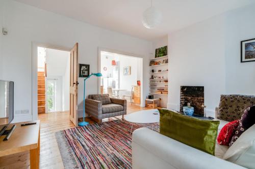 a living room with a couch and a fireplace at Bright Two Bedroom Apartment Near Vibrant Camden Town in London