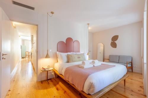 a bedroom with a large bed with a pink headboard at D&S - JB Apartments in Porto