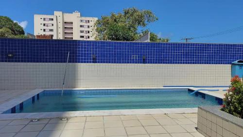 a swimming pool with a blue tile wall at Conforto e tranquilidade, 2 quartos, próximo à praia in Maceió