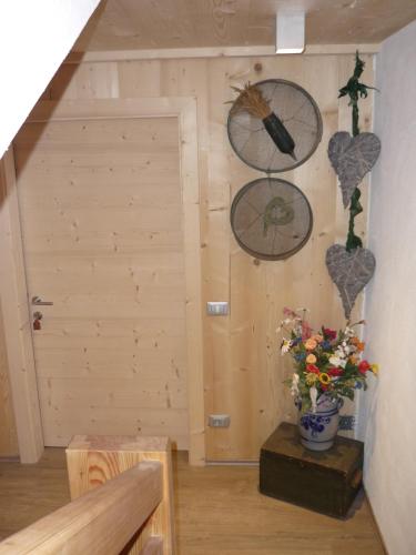 a room with clocks on the wall and a vase of flowers at Apartments Resi in Rasùn di Sotto