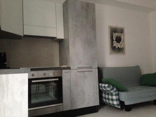 uma cozinha com um fogão e um sofá num quarto em B&B 208 em Tróia