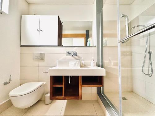 リヴィエール・ノワールにあるLuxury Waterfront Apartmentの洗面台とシャワー付きのバスルーム