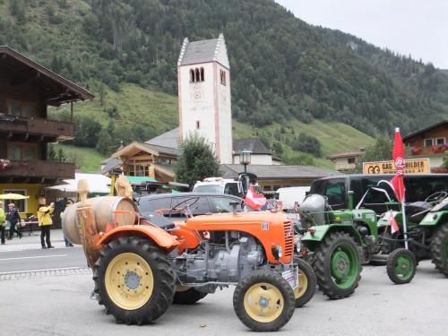 a group of tractors parked in front of a clock tower at Apart-Pension Oberreiter in Fusch an der Glocknerstraße
