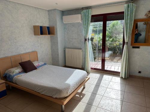 a bedroom with a bed and a sliding glass door at Casa Peseta, Casa Rural in Vallada
