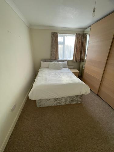 a small bedroom with a bed and a window at NKY Sweet 3 Bed House Apartment in London