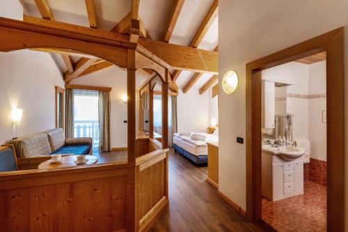 a living room with a couch and a sink at Hotel Terme Antico Bagno in Pozza di Fassa