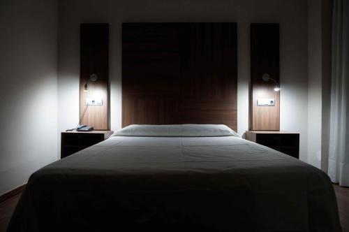 a bedroom with a large bed with two night stands at Cesaraugusta in Zaragoza