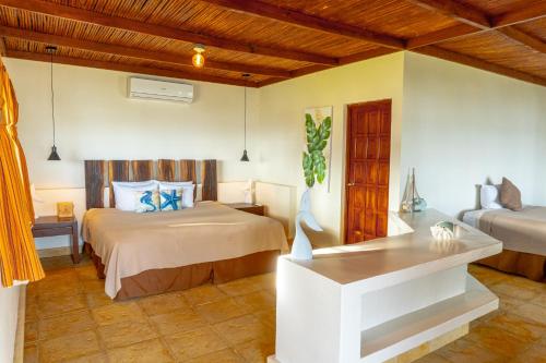 1 dormitorio con 2 camas y mesa. en Casa del Golfo El Salvador, en Conchagua