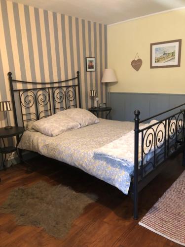 sypialnia z łóżkiem i ścianą w paski w obiekcie Les Forges w mieście Saint-Sornin-la-Marche