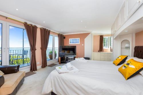a large bedroom with a large white bed with yellow pillows at Seahaven in Torquay