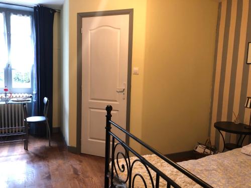 sypialnia z łóżkiem i białymi drzwiami w obiekcie Les Forges w mieście Saint-Sornin-la-Marche