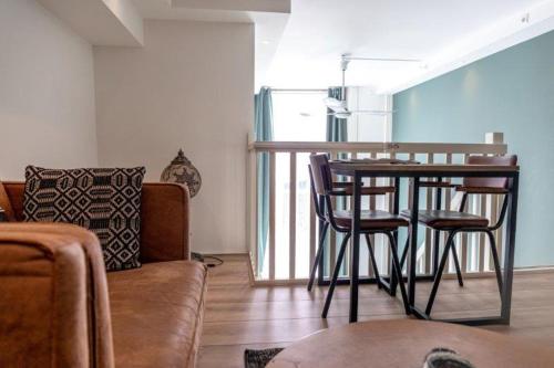 ein Wohnzimmer mit einem Tisch, Stühlen und einem Sofa in der Unterkunft 1001 Nights Boutique Lofts in Haarlem