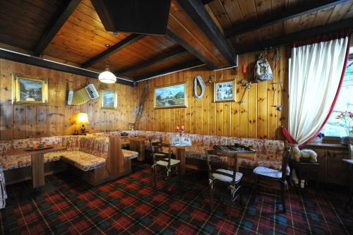 a restaurant with wooden walls and tables and chairs at Hotel Etoile De Neige in Valtournenche
