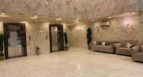 eine große Lobby mit Sofas und einer Marmorwand in der Unterkunft غيوم in Mekka
