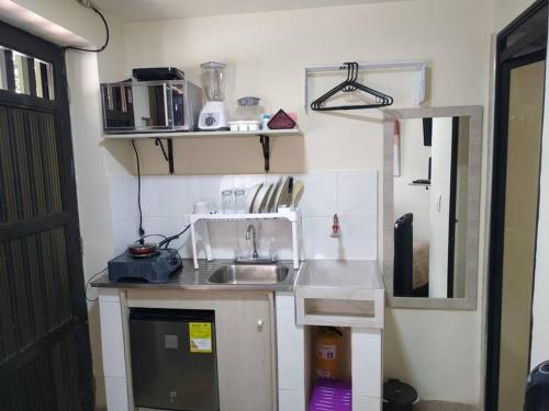 una pequeña cocina con lavabo y espejo en Acogedor aparta estudio en Medellín, en Medellín