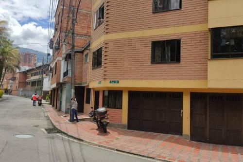 un hombre parado en una acera al lado de un edificio en Acogedor aparta estudio en Medellín, en Medellín
