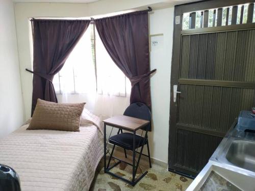 1 dormitorio con cama, mesa y ventana en Acogedor aparta estudio en Medellín, en Medellín