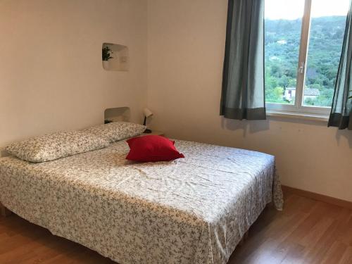 Un dormitorio con una cama con una almohada roja. en La Villetta di Cefalù, en Cefalú