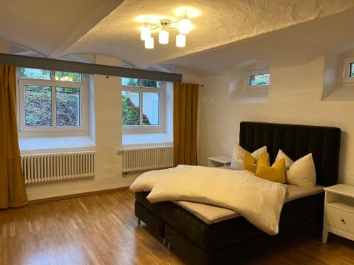 1 dormitorio con 1 cama con almohadas amarillas en ARYVE ErfurterLoft - Boutique Loft zentrumsnah mit kostenfreien Parkplätzen, Design-Interieur und Netflix, en Erfurt