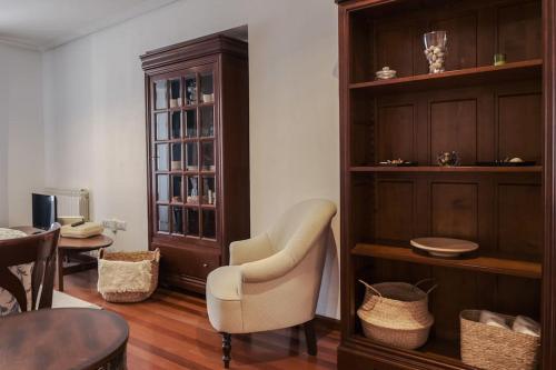 een woonkamer met een stoel en een boekenplank bij La casina de cori in Luarca