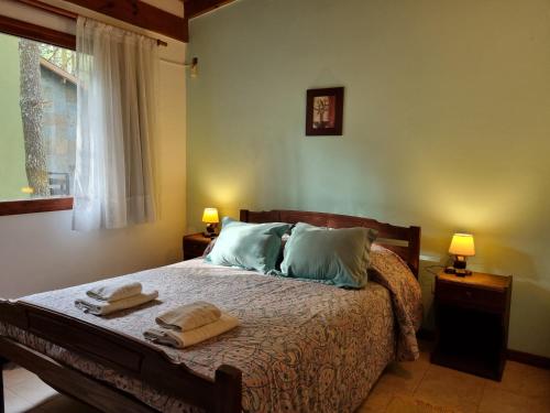 a bedroom with a bed with two towels on it at Cabañas Hurra Pampa in Mar de las Pampas