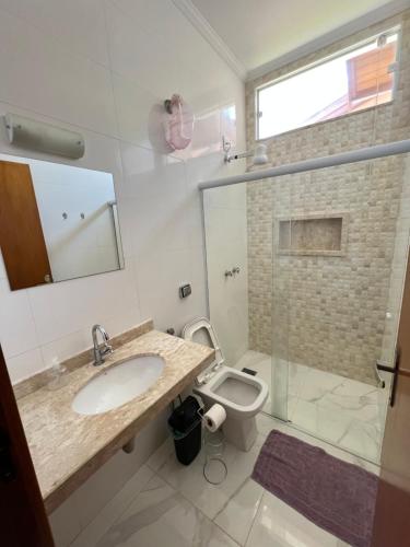 een badkamer met een wastafel en een toilet bij Casa c/ quartos separados + churrasqueira ampla. in Brotas