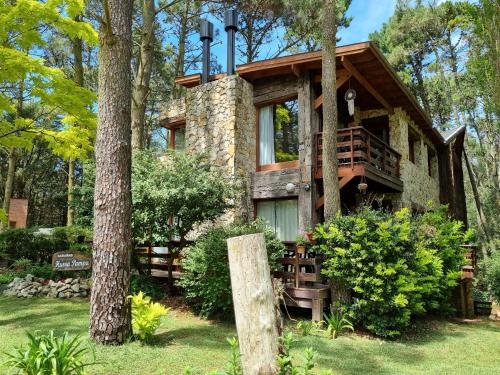 a house in the woods with a tree at Cabañas Hurra Pampa in Mar de las Pampas