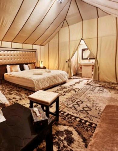 メルズーガにあるLuxury Desert Campのテント内のベッド1台が備わるベッドルーム1室